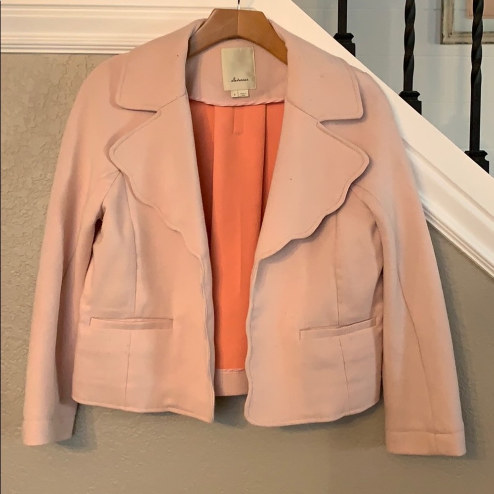Pink cropped jacket with scallop trim.